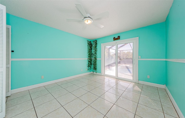 tiled empty room with a textured ceiling and ceiling fan