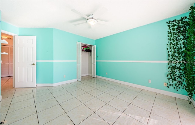 empty room with ceiling fan and light tile patterned flooring