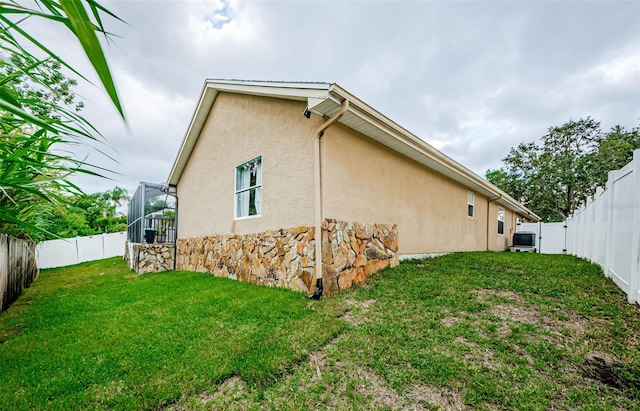 view of property exterior featuring central AC unit and a yard