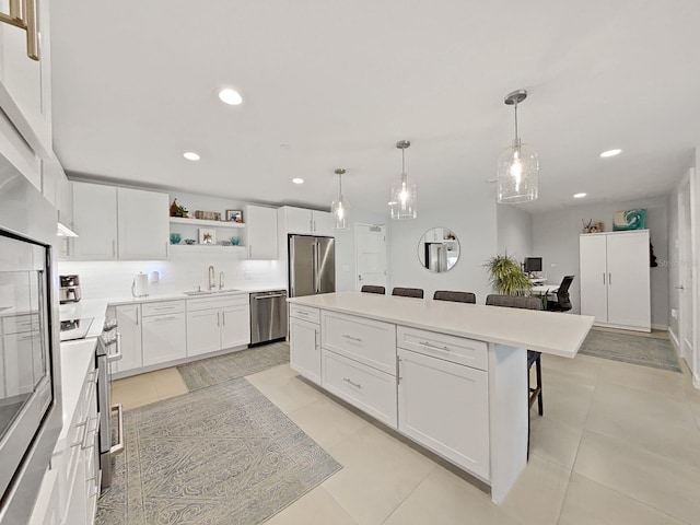 kitchen featuring sink, stainless steel appliances, a kitchen breakfast bar, and white cabinets