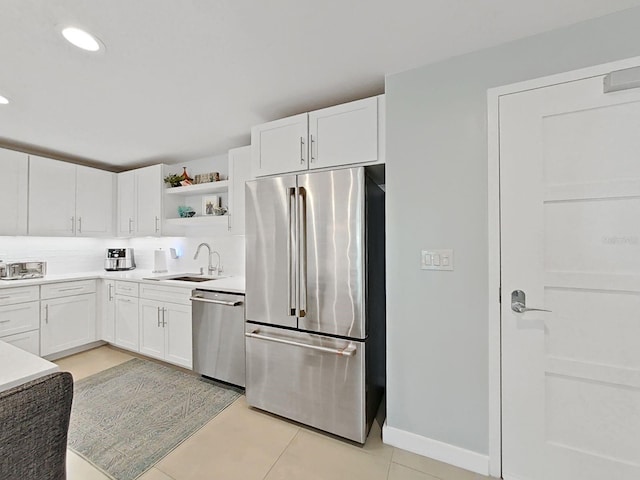 kitchen featuring white cabinetry, appliances with stainless steel finishes, sink, and light tile patterned floors