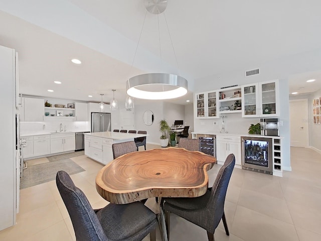 dining area with wine cooler, sink, and light tile patterned flooring