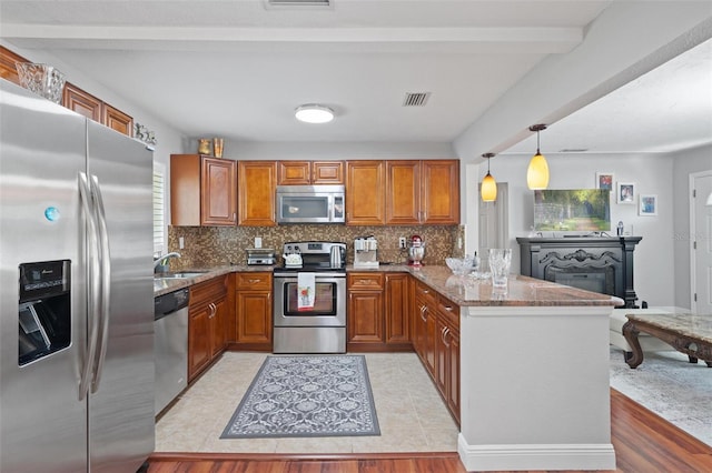 kitchen featuring light tile patterned flooring, kitchen peninsula, stainless steel appliances, beamed ceiling, and decorative backsplash