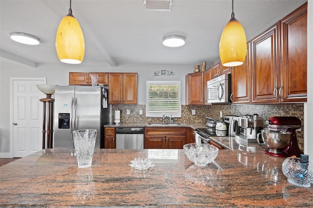 kitchen with hanging light fixtures, stainless steel appliances, and tasteful backsplash