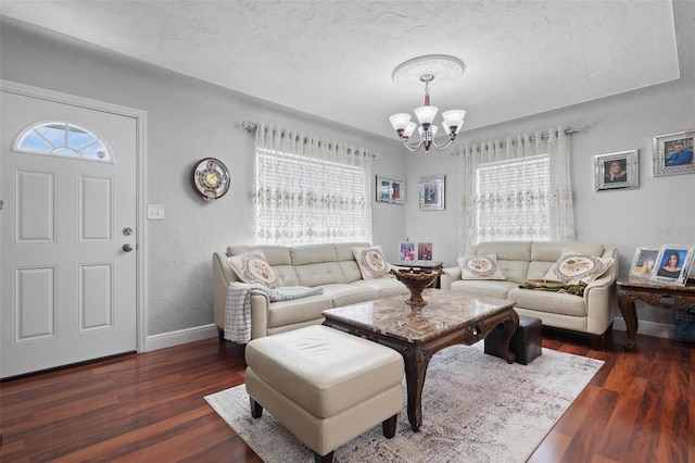 living room featuring plenty of natural light, dark hardwood / wood-style floors, a notable chandelier, and a textured ceiling