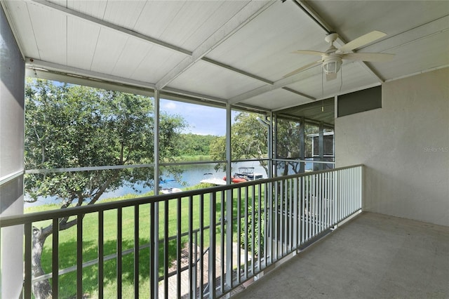 unfurnished sunroom with a water view and ceiling fan