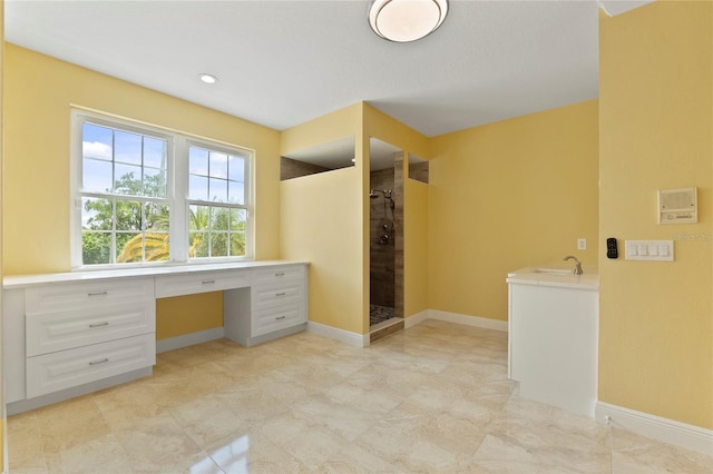 bathroom featuring a tile shower and sink