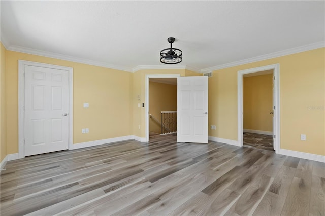 unfurnished room featuring ornamental molding and light wood-type flooring