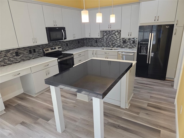 kitchen featuring a sink, tasteful backsplash, light wood-style floors, and black appliances