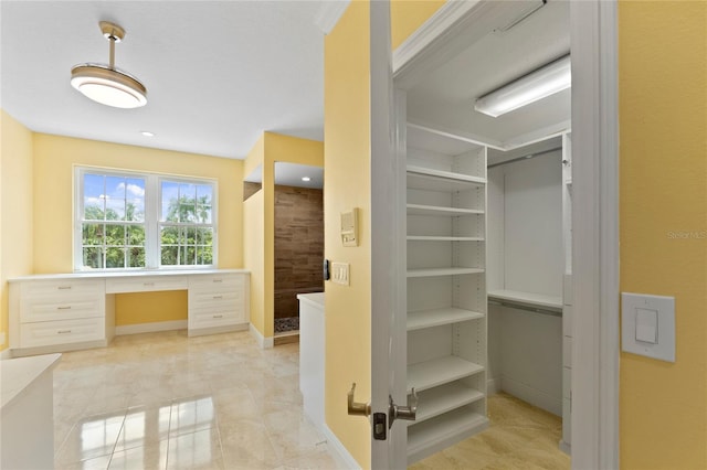 spacious closet featuring built in desk