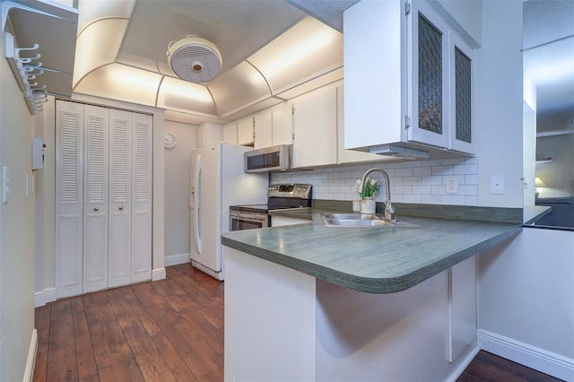 kitchen featuring sink, tasteful backsplash, kitchen peninsula, stainless steel appliances, and white cabinets