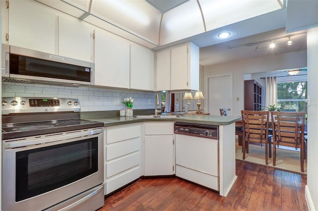 kitchen with stainless steel appliances, sink, dark wood-type flooring, and white cabinets