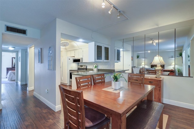 dining area featuring dark hardwood / wood-style flooring, sink, and a textured ceiling