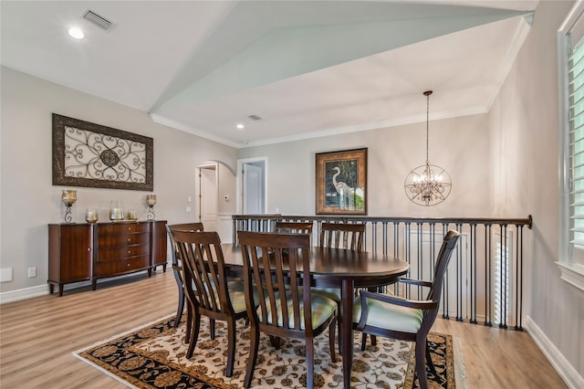 dining area with vaulted ceiling, ornamental molding, a chandelier, and light hardwood / wood-style floors