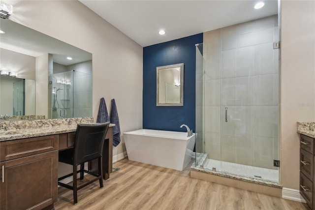 bathroom featuring hardwood / wood-style flooring, vanity, and plus walk in shower