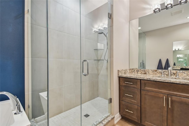 bathroom featuring an enclosed shower and vanity