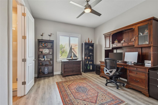 office with light wood-type flooring and ceiling fan