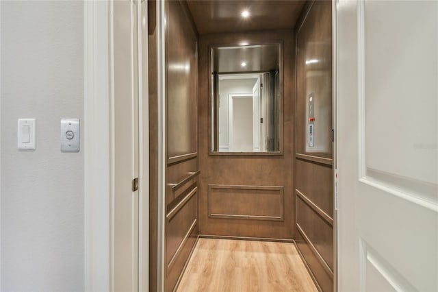 interior details with hardwood / wood-style flooring and elevator