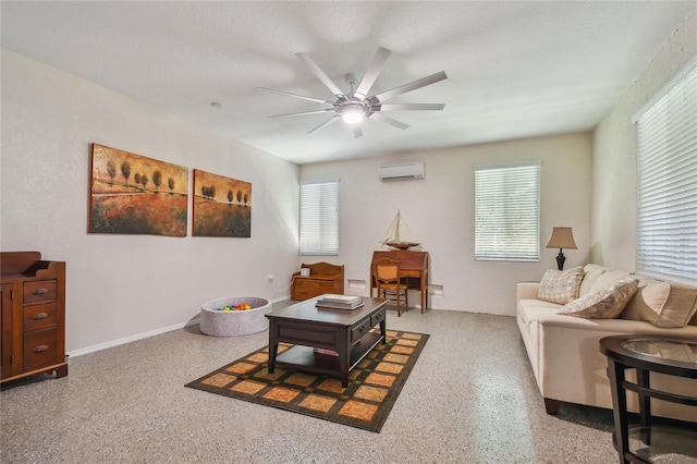 sitting room with a healthy amount of sunlight, a wall unit AC, and ceiling fan