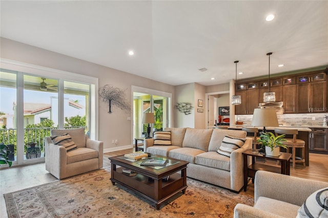 living room with ceiling fan and light wood-type flooring