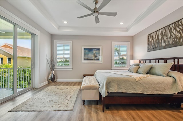 bedroom with a raised ceiling, access to exterior, ceiling fan, and light hardwood / wood-style floors