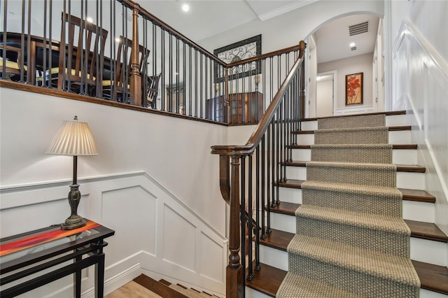 stairway featuring ornamental molding