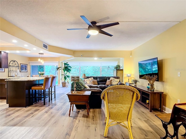 living room with light hardwood / wood-style flooring, a wealth of natural light, and ceiling fan