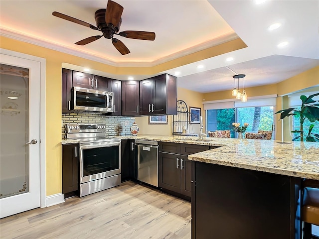 kitchen with decorative light fixtures, sink, light hardwood / wood-style floors, dark brown cabinetry, and stainless steel appliances