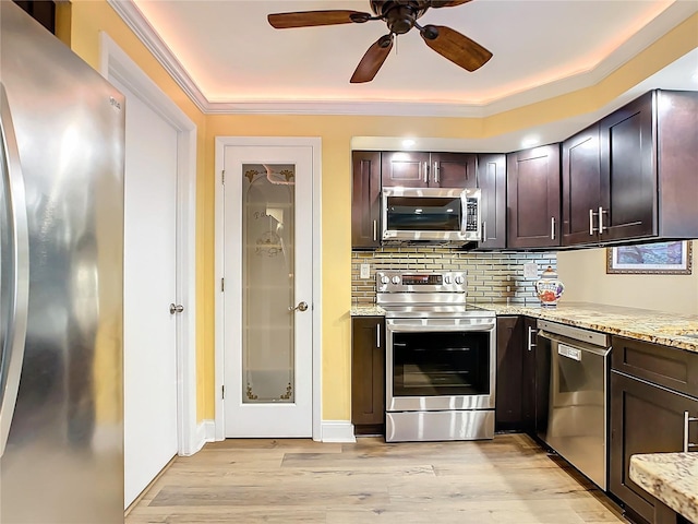 kitchen with tasteful backsplash, appliances with stainless steel finishes, dark brown cabinets, and light stone counters