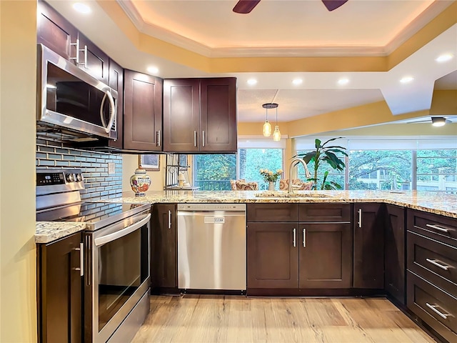 kitchen with sink, ceiling fan, appliances with stainless steel finishes, tasteful backsplash, and light stone countertops