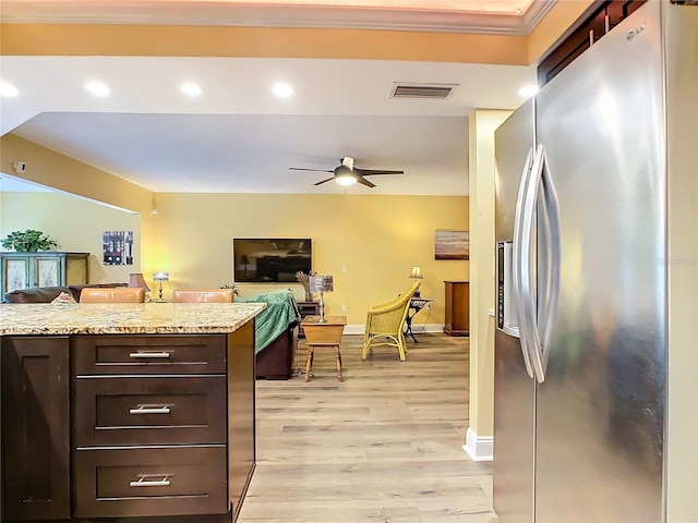 kitchen with light stone counters, ceiling fan, stainless steel refrigerator with ice dispenser, dark brown cabinets, and light wood-type flooring