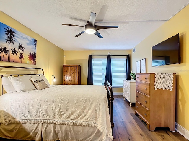 bedroom featuring ceiling fan, wood-type flooring, and a textured ceiling