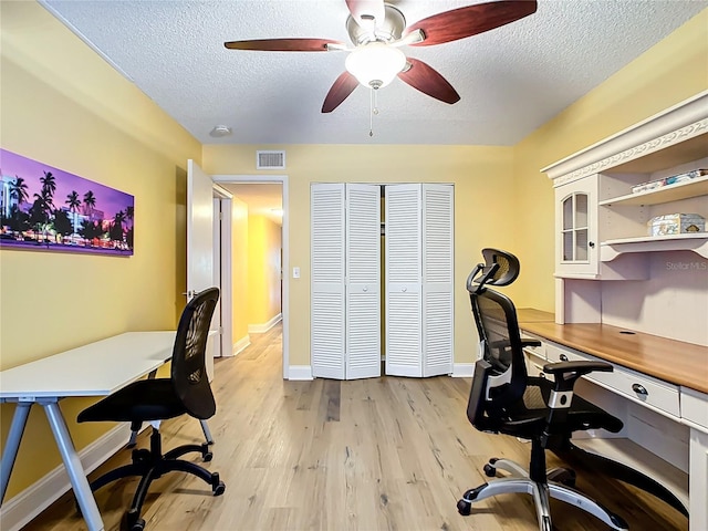 office space featuring ceiling fan, light hardwood / wood-style flooring, and a textured ceiling