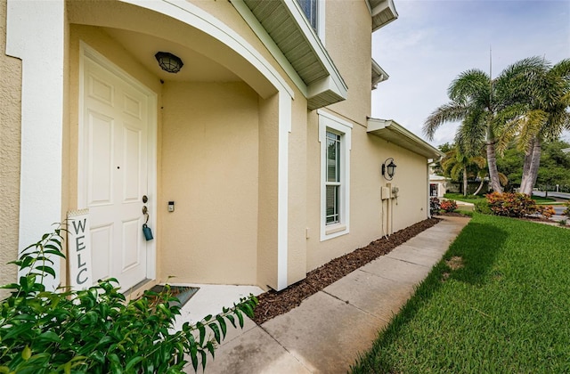 entrance to property with a lawn