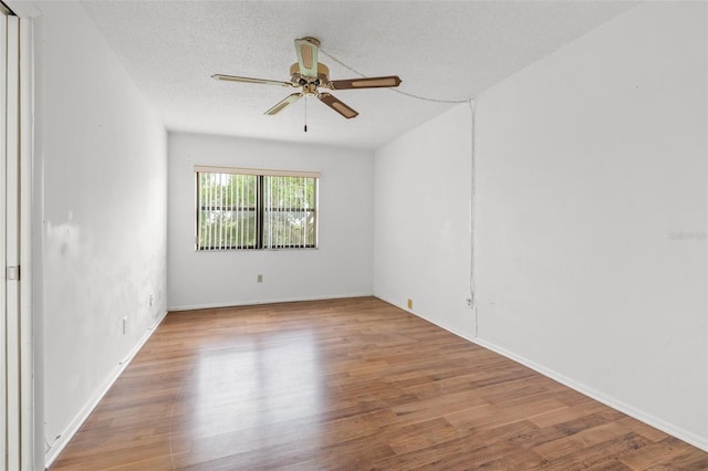 spare room with ceiling fan, a textured ceiling, and light wood-type flooring