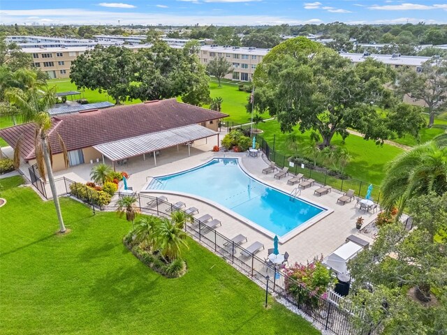 view of pool with a patio and a lawn