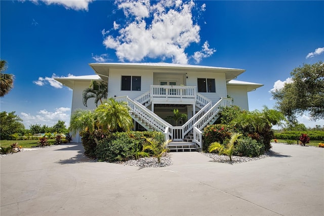 raised beach house featuring covered porch