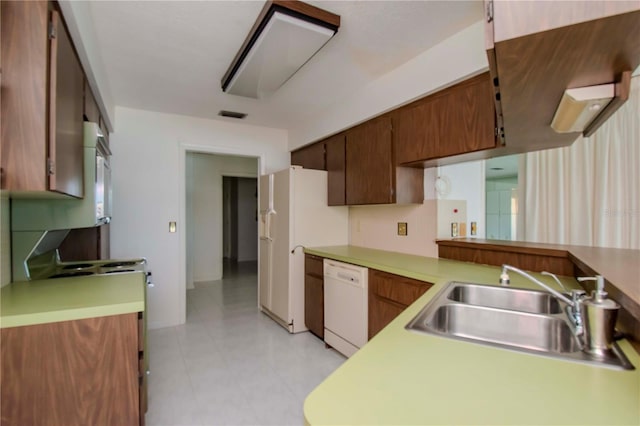 kitchen featuring light tile patterned flooring, white dishwasher, and sink