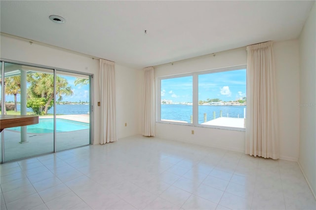 tiled empty room featuring a water view