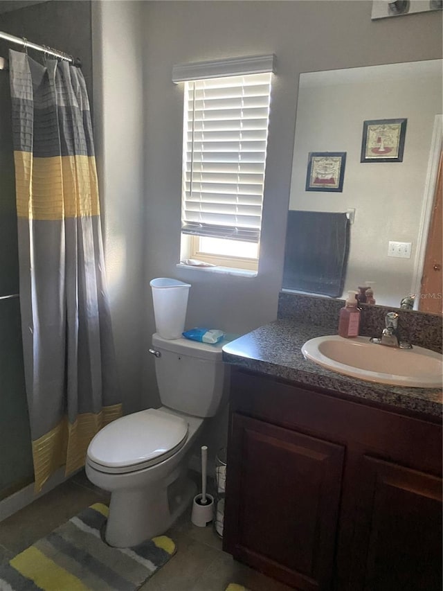 bathroom featuring a shower with curtain, vanity, toilet, and tile patterned flooring