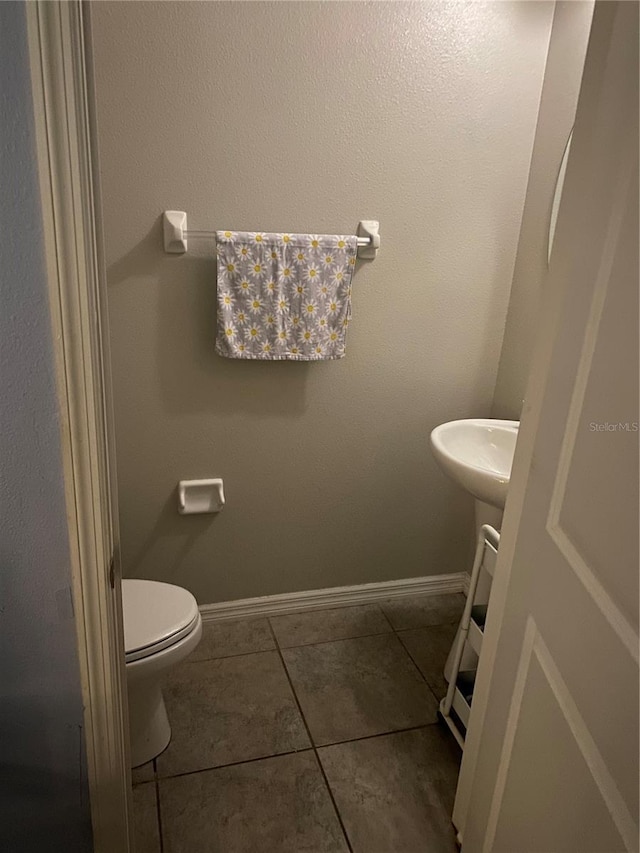 bathroom with sink, toilet, and tile patterned floors