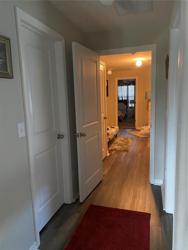 hallway with hardwood / wood-style flooring