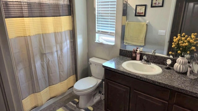 bathroom with vanity, toilet, curtained shower, and tile patterned flooring