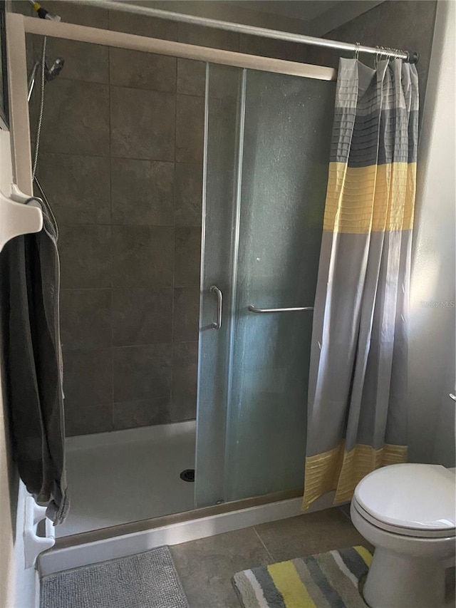 bathroom with toilet, tile patterned floors, and a shower with shower curtain