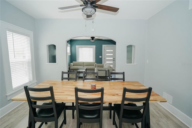 dining space with ceiling fan, a wealth of natural light, and light hardwood / wood-style floors