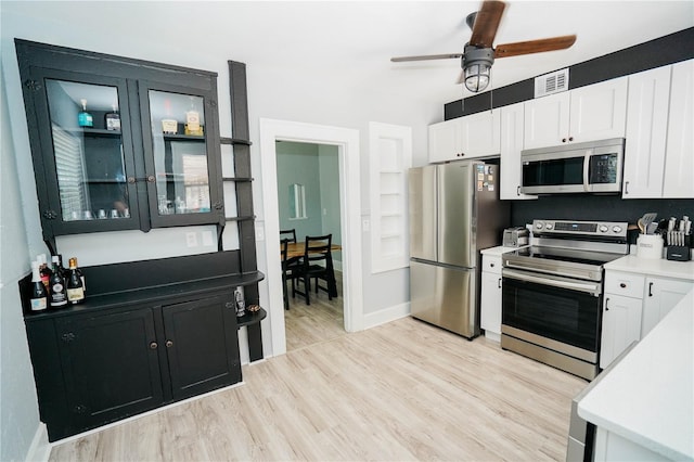 kitchen featuring ceiling fan, white cabinets, appliances with stainless steel finishes, and light hardwood / wood-style flooring