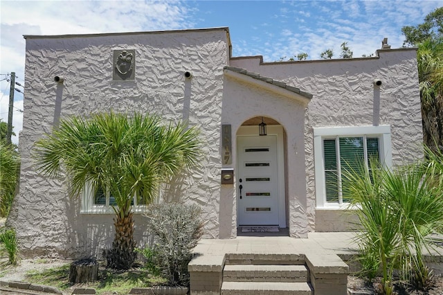 entrance to property with stucco siding