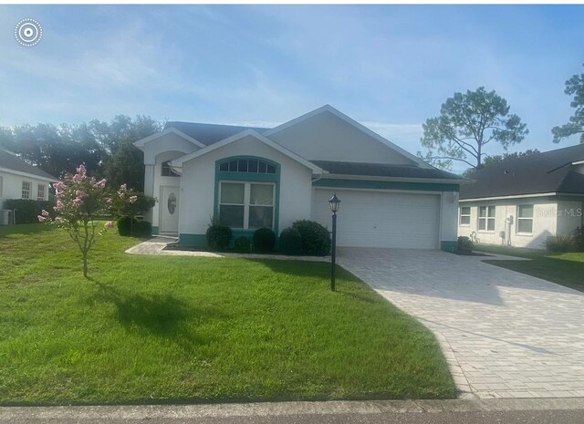 ranch-style home with a garage and a front lawn