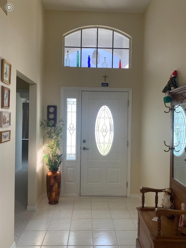 foyer entrance featuring light tile patterned flooring and a high ceiling