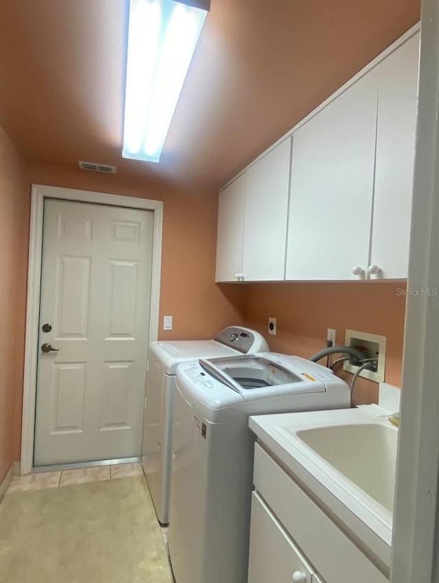 laundry room featuring sink, independent washer and dryer, and cabinets